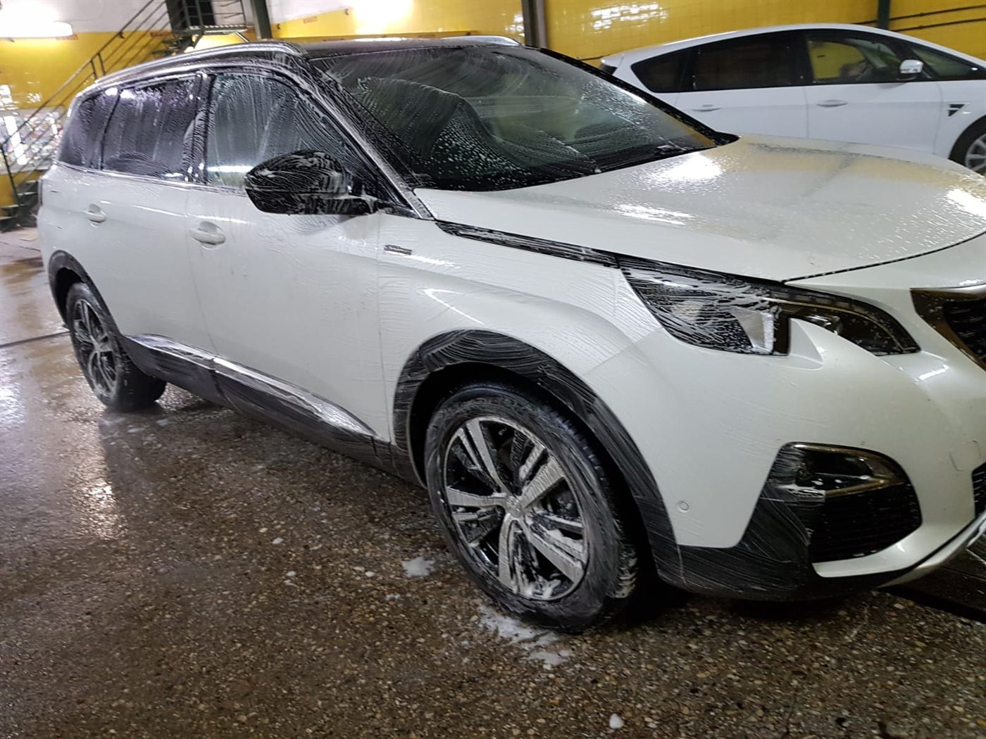 Un coche enjabonado en el túnel de lavado.